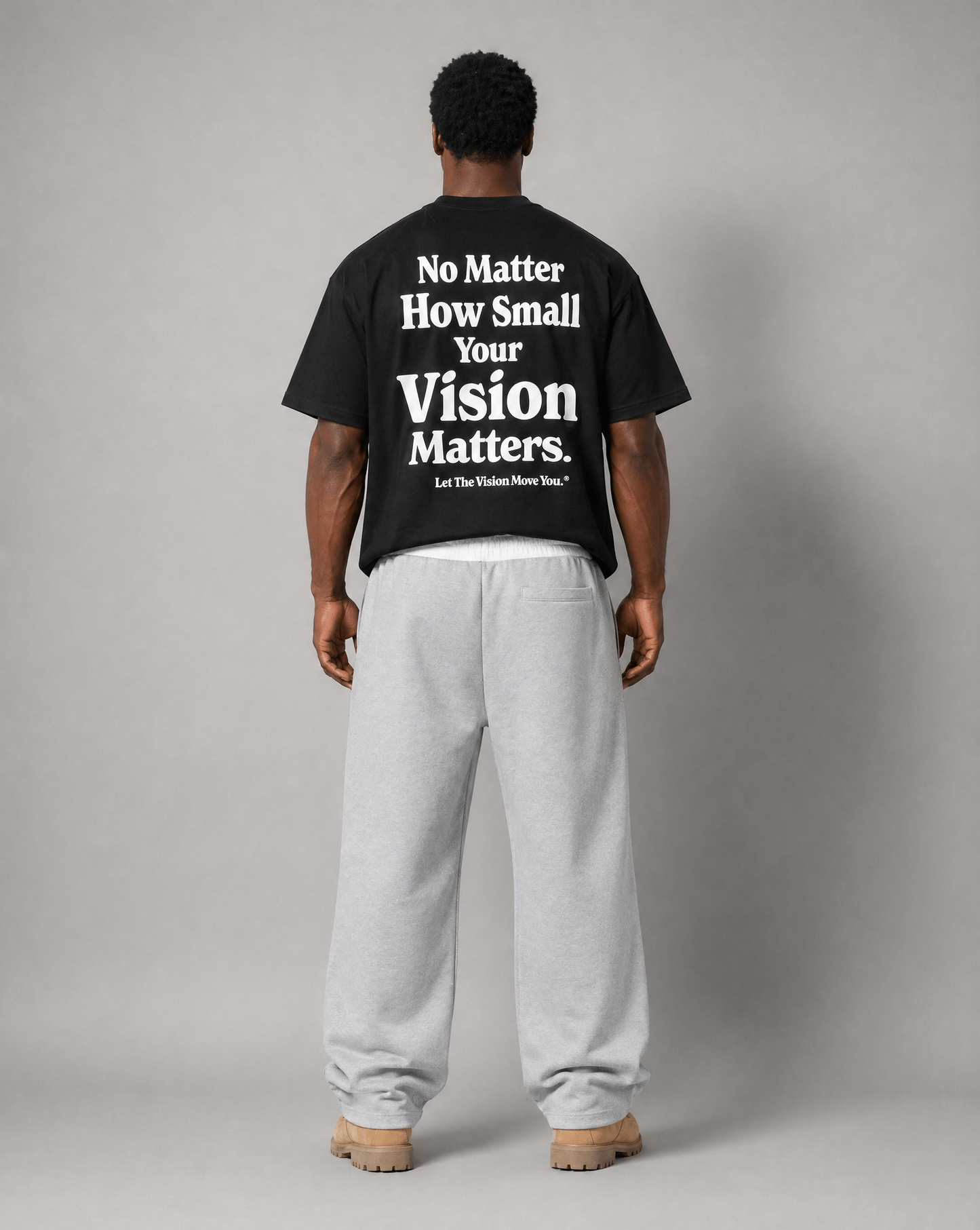 Man standing up showing text on back of shirt saying "no matter how small your vision matters."