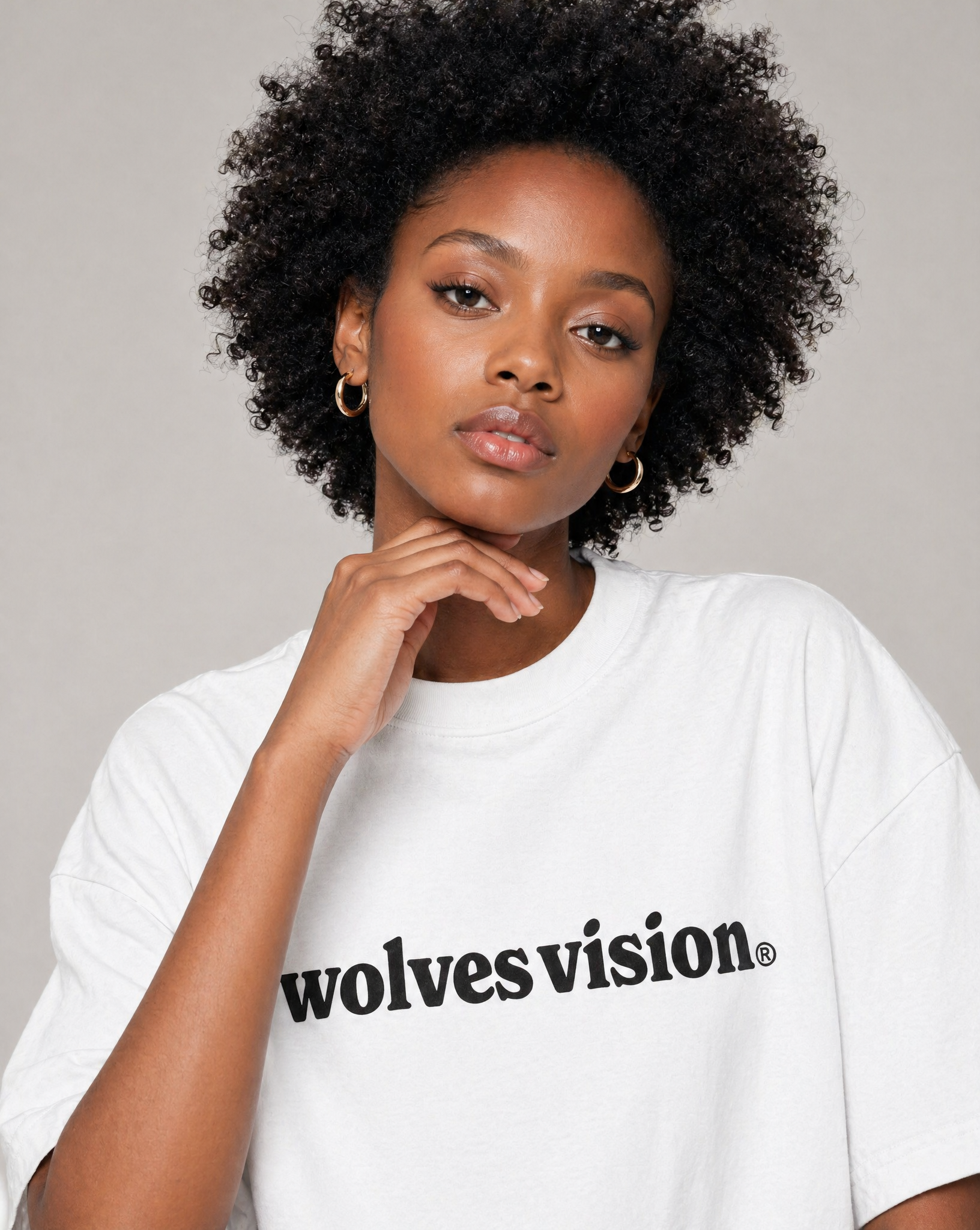A Close up Picture of a black woman wearing a white t-shirt saying "wolvesvision®".