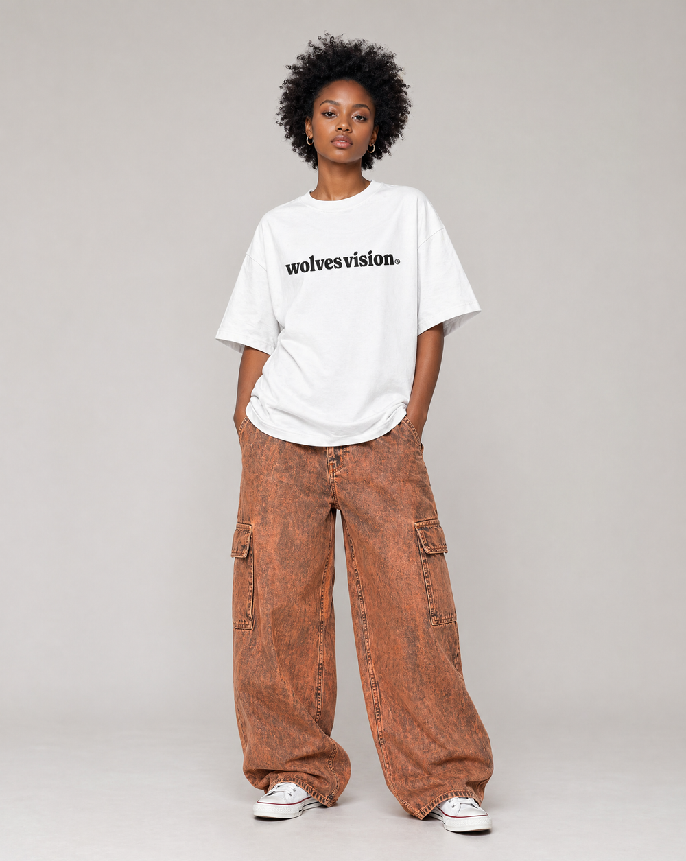 Person wearing a white t-shirt with 'wolvesvision' text and brown cargo pants on a gray background