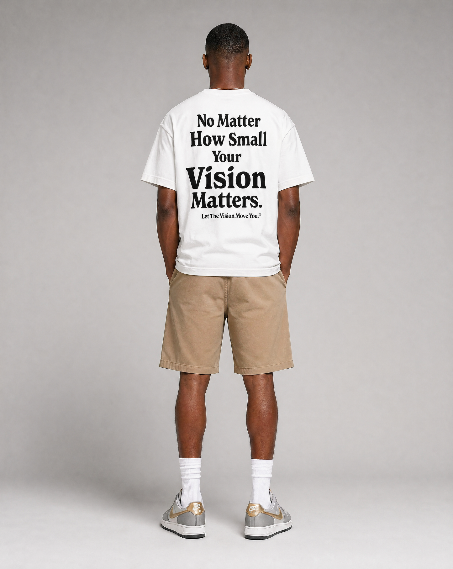Person wearing a white t-shirt with motivational text on the back, standing against a plain background.
