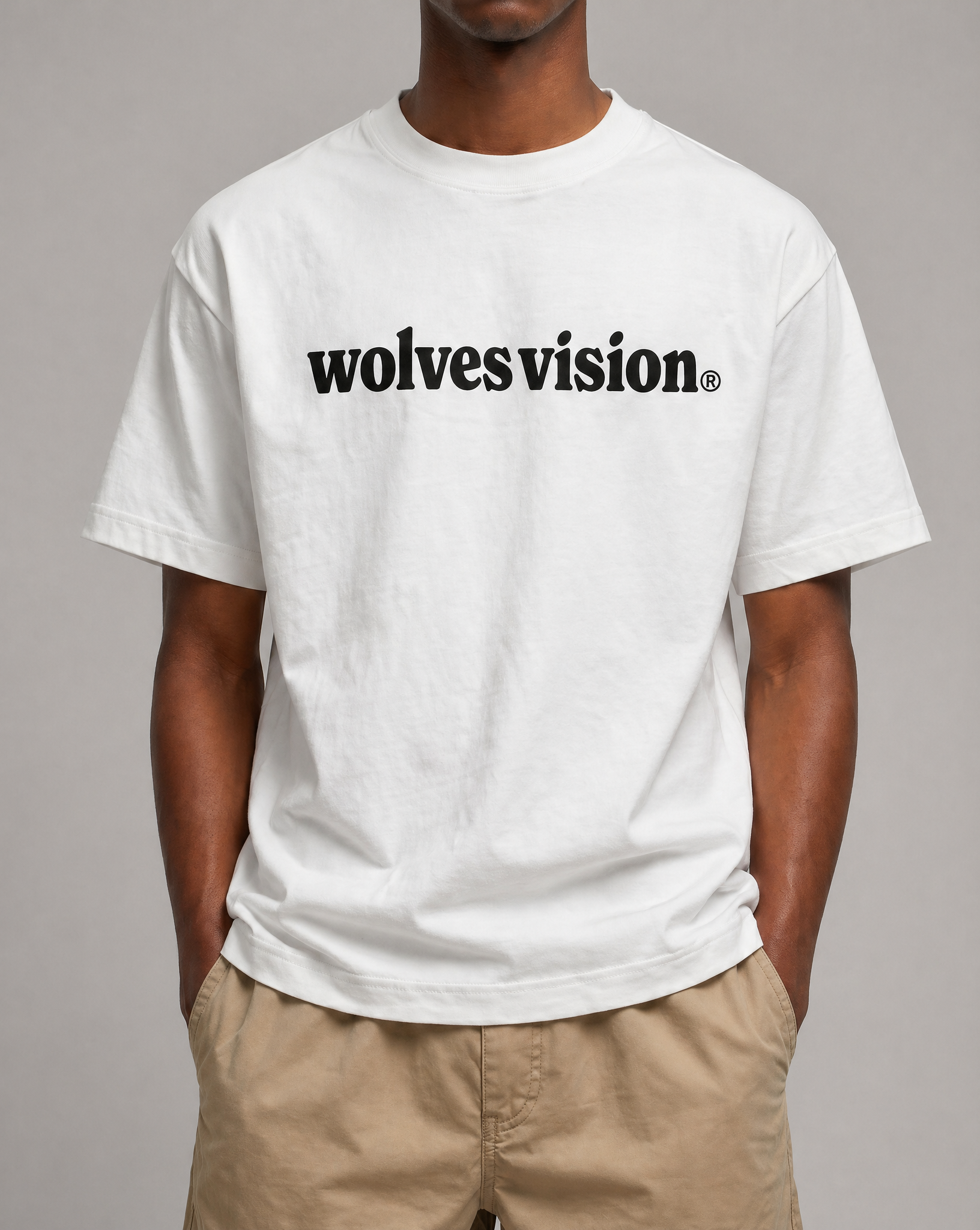 Person wearing a white t-shirt with 'wolvesvision' text on a gray background