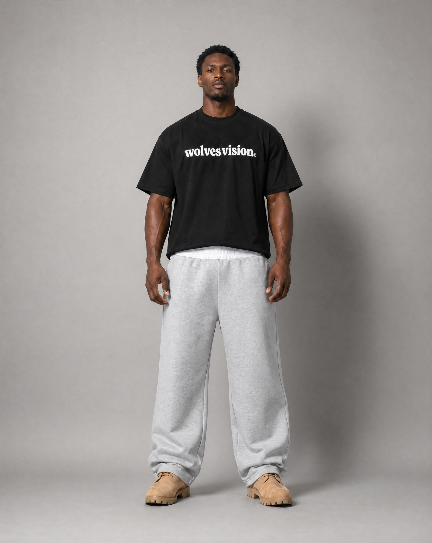 Black man standing up wearing black shirt with text "wolves vision".