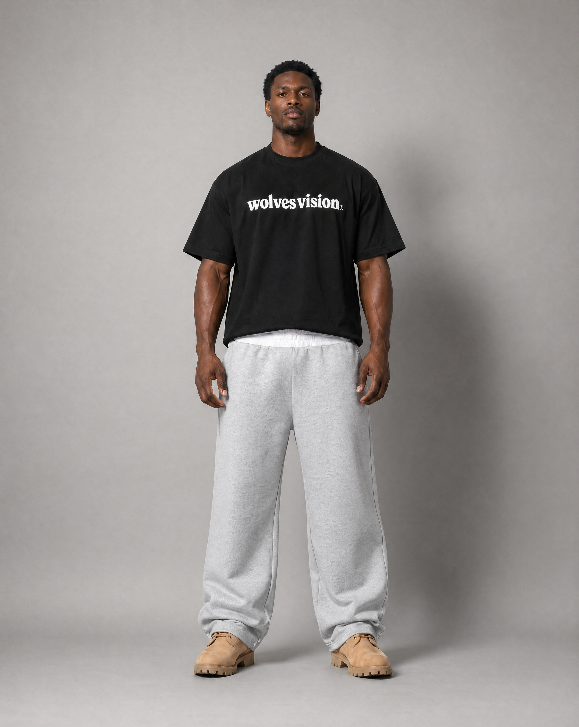 Black man standing up wearing black shirt with text "wolves vision".