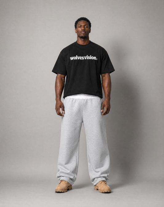 Black man standing up wearing black shirt with text "wolves vision".